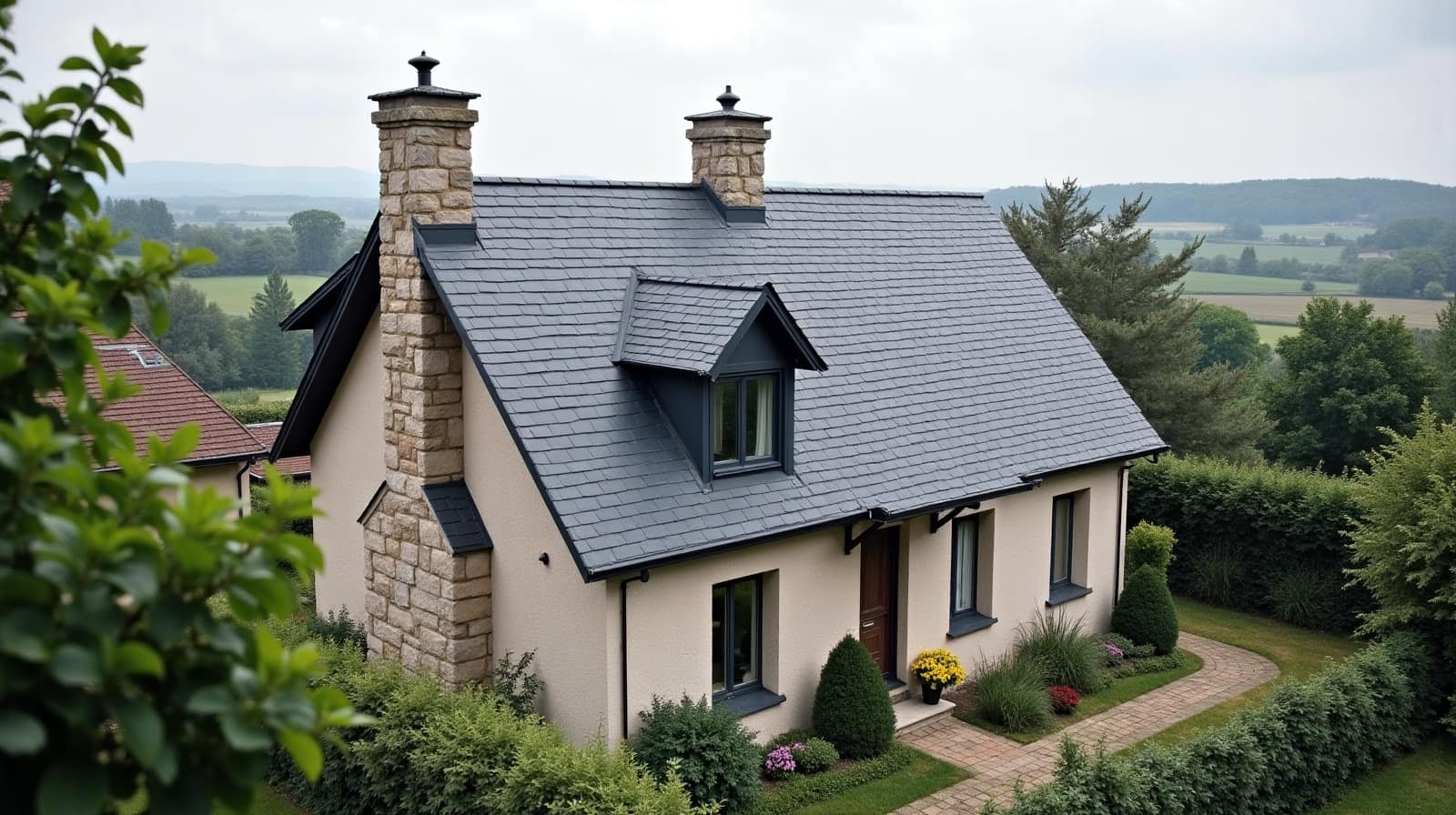Toiture en ardoise sur une maison entourée de champs à Hermes, vue depuis les hauteurs